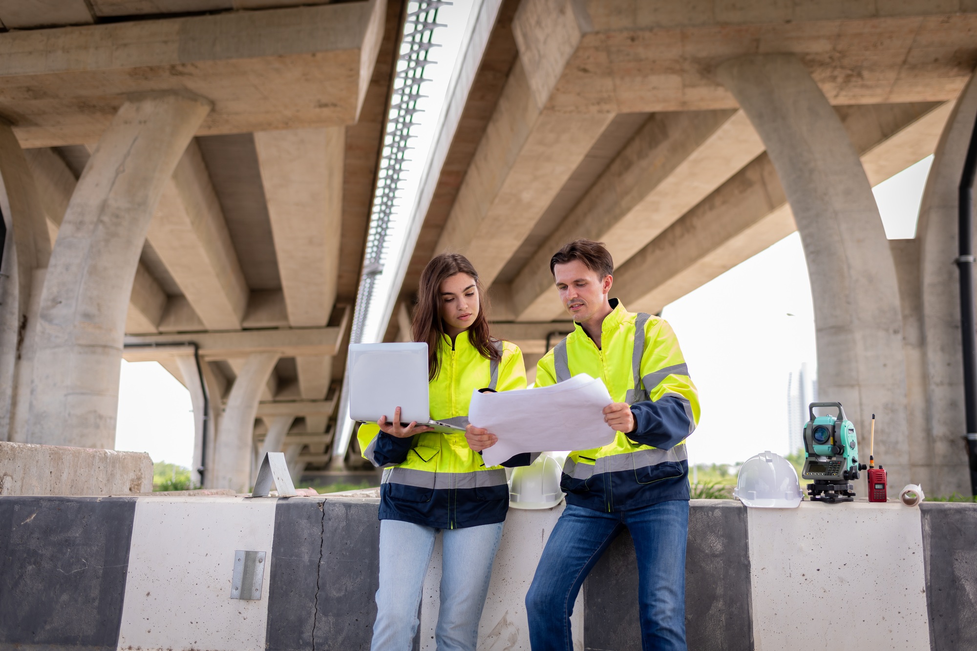 Portrait surveyors wearing uniform conversation notebook and blueprint check inspection by theodolit